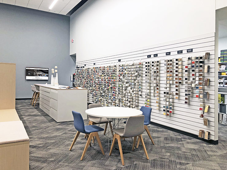 Design resource library featuring a collaborative high-top, a small group table, and a wall of fabric swatch samples